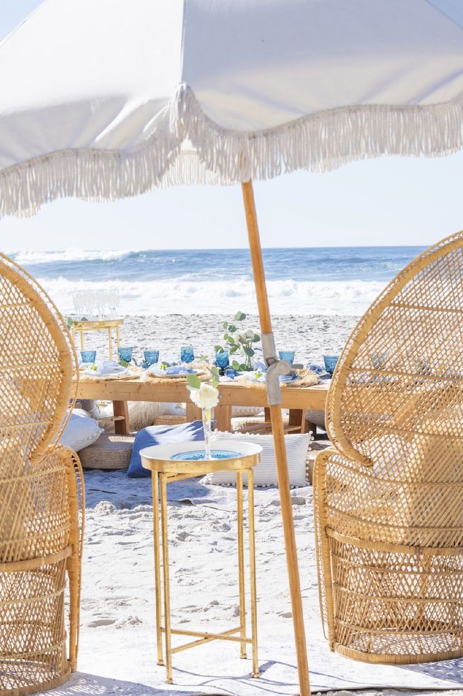Elegant outdoor picnic setup with low table, cushions and coastal styling